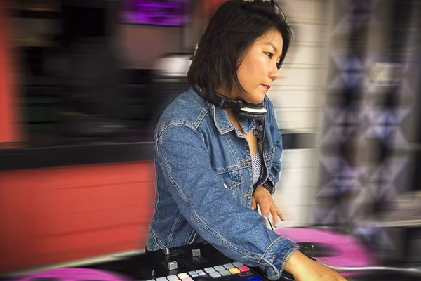 DJ Yuna performing live, expertly mixing tracks with energy and style. With a dynamic stage presence and seamless beats, she creates an electrifying atmosphere, perfect for corporate events, parties, and high-profile celebrations.