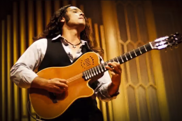 Russ Hewitt performing live on stage, skillfully playing his guitar with passion and precision.